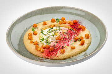 Chickpea hummus on a decorative ceramic plate. White background.