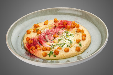 Chickpea hummus on decorative ceramic plate. Gray background.
