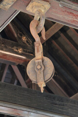 A Large Ceiling Mounted Industrial Pulley and Hook.