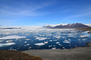 Glacial Lagoon with Ice Flow and Scenic Mountains