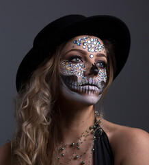  close-up young woman with make-up for the festival Day of the Dead - Dia de los Muertos - a holiday dedicated to the memory of the dead. on a gray background 