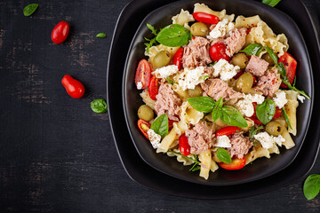 Pasta with tuna, tomatoes and feta cheese. Pasta salad with tuna. Healthy italian food. Healthy dinner. Top view, flat lay
