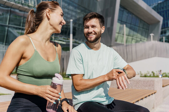 Use a fitness watch and a bracelet for the application, a rest break. A woman and a man doing running sports are getting ready to run. Friends run together. Fitness exercises