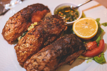 Fried grilled carp, roasted carp fish on plate with lemon and salad served in a traditional restaurant in Montenegro, Skadar lake, prepared cooked crucian carp steak, balkan dish, Montenegrin cuisine