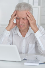 Senior businessman working with his laptop at office