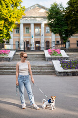 A young red-haired woman in casual clothes with her dog, Jack Russell Terrier