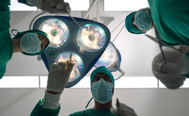 Gowned experts, lost amid the profound concentration amidst the intense surgical lights of a...