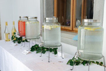 Jars with water and lemon slices at a wedding buffet
