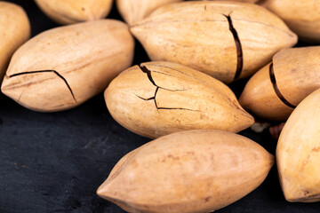 cracked unpeeled pecans close-up on the table