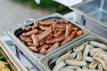 Sausages in a silver tray at a garden party bbq buffet
