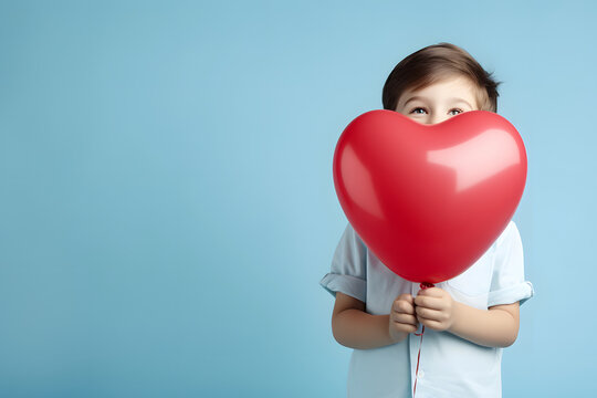 boy with a red heart balloon, a child patient holding a heart balloon isolated on a blue background, World Heart Day concept