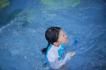 Fototapeta na wymiar 夏のプールで遊んでいる一人の子供の様子