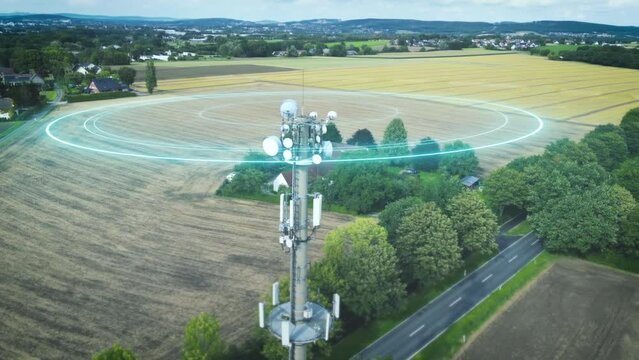 Antenna tower in landscape with isolated houses transmits strong communication waves signals. Drone shot, concept modern data transmission