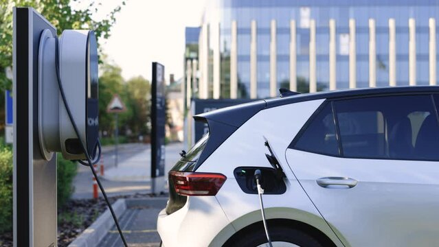Electric vehicle parking at the charging station. Electric vehicle battery cell recharging. Zero emission vehicle on EV only charging station is parked