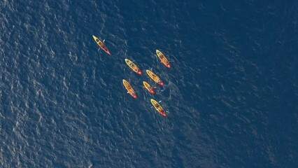 Group of people kayaking in open sea ocean. Outdoor activities aerial view from above