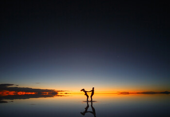Uyuni salt marsh. Shadows of people at sunset