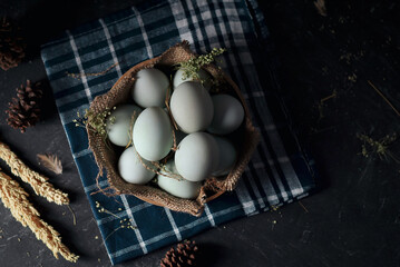 fresh duck eggs on bamboo basket and sackcloth with dark and texture background. Duck Egg Yolk salted