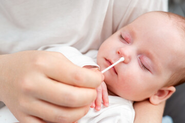 Mother ensures nasal hygiene for newborn, Concept of gentle care routines