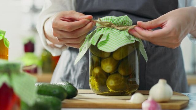 Pickled, housewife woman cooking pickles cucumbers in the kitchen of a private house. farm owner cooking ingredients for canning learns new recipes for canned vegetables