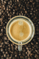 Cup of coffee with coffee beans in the background