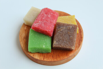Yangko is traditional snack from Yogyakarta, Indonesia. Made from glutinous rice powder. Colorful yangko on wooden plate, isolated on white background