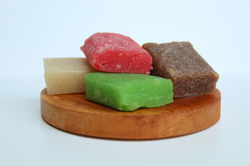 Yangko is traditional snack from Yogyakarta, Indonesia. Made from glutinous rice powder. Colorful yangko on wooden plate, isolated on white background