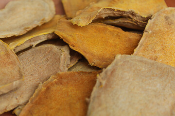 Sliced and dried rhizome of Curcuma zanthorrhiza, or temulawak, or Java ginger, or Javanese ginger, or Javanese turmeric. Flat lay or top view as background