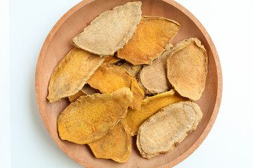 Sliced and dried rhizome of Curcuma zanthorrhiza, or temulawak, or Java ginger, or Javanese ginger, or Javanese turmeric. Isolated on white background. Flat lay or top view