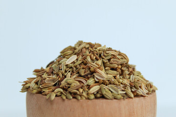 Dried Aniseed, or Pimpinella Anisum seed, or Adas Manis, inside wooden bowl. Isolated on black background
