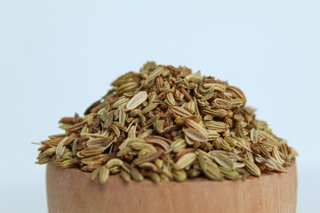 Dried Aniseed, or Pimpinella Anisum seed, or Adas Manis, inside wooden bowl. Isolated on black background