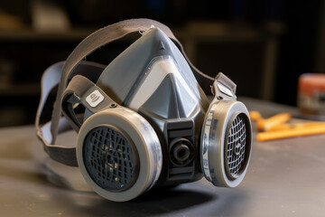 Highlighting the significance of safeguarding respiratory health in high-risk workplaces, behold a detailed shot of a respirator mask featuring interchangeable filters.