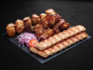 A set of grilled meat. Lula kebab, pork gammon, veal steak and baked potatoes. Isolated on a dark background