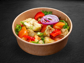 Grilled vegetables, tomatoes, eggplant, peppers. In a takeaway package. Isolated on a dark background