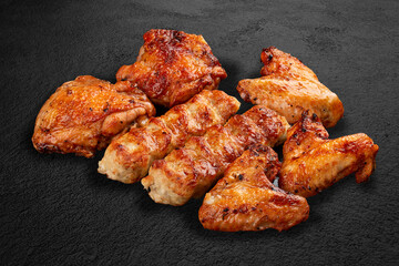 Grilled chicken wings on a dark stone background. BBQ menu