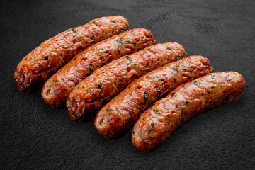 Grilled pork sausages, kupatas, handmade on a dark stone background. BBQ menu
