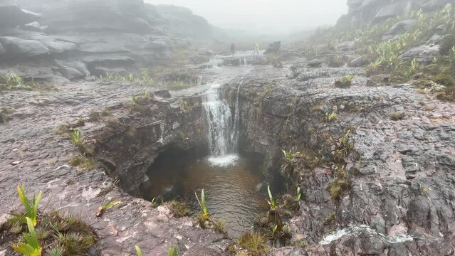 Streams of rainwater flow into big stone opening on top of Tepuy Roraima Mount, 