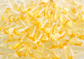 Cod-liver oil (vitamin D, E, A, cosmetic serum) supplement softgel capsules. Close-up, selective focus