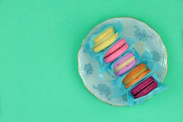 Marshmallows in plate on green background. Traditional colored sweet desserts for the holiday.