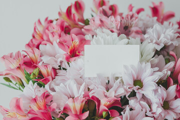 close up Bright beautiful bouquet of alstroemerias and chrysanthemums with an empty gift card for your text