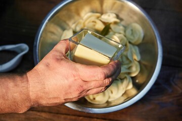 Ready-cooked dumplings in a bowl with spices and butter.