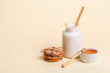 Milk, honey and tasty cookies with chocolate pieces on a blue background. Breakfast or snack idea.