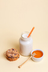 Milk, honey and tasty cookies with chocolate pieces on a blue background. Breakfast or snack idea.