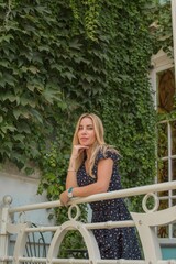 Beautiful blonde girl in a nice little French courtyard with flowers wearing cotton dress