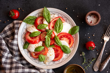 Caprese salad with mozzarella cheese and tomatoes of Italian cuisine