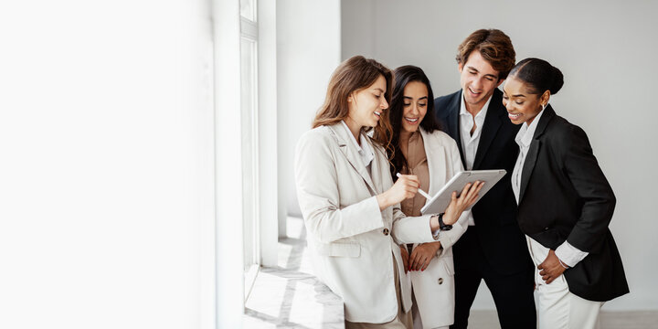 Businesswoman discussing new project with her multiracial business team, using digital tablet, panorama, free space
