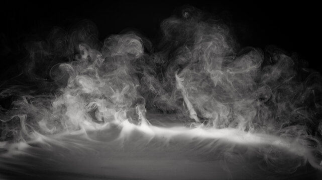 Smoke, fog or steam on black background flowing or rolling from center to edges