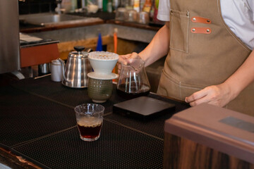 Professional barista pour dripped coffee into glasses and serve to customers. concept of dipping...