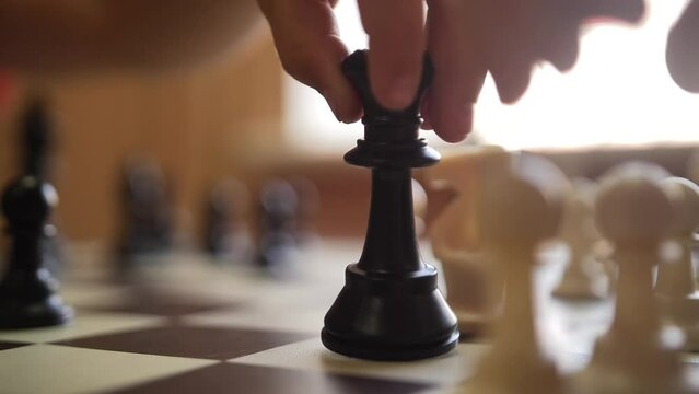 Close-up of a Hand Moving a Chess Piece on the Board. Chess Tournament. Hands, people and chess board game in closeup.