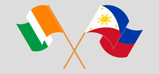 Crossed and waving flags of Ivory Coast and the Philippines