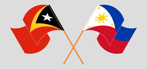 Crossed and waving flags of East Timor and the Philippines
